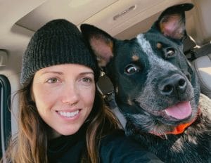 Jakki Overby with her dog, Wylie, are inside a car.