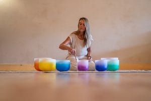 Kimberlee Grogan, intuitive sound bath, sound meditation pracitioner, plays crystal sound bowls during a sound bath in duluth mn