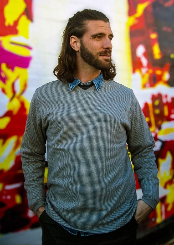 portrait of artist Paul Lajeunesse in front of a brightly colored background