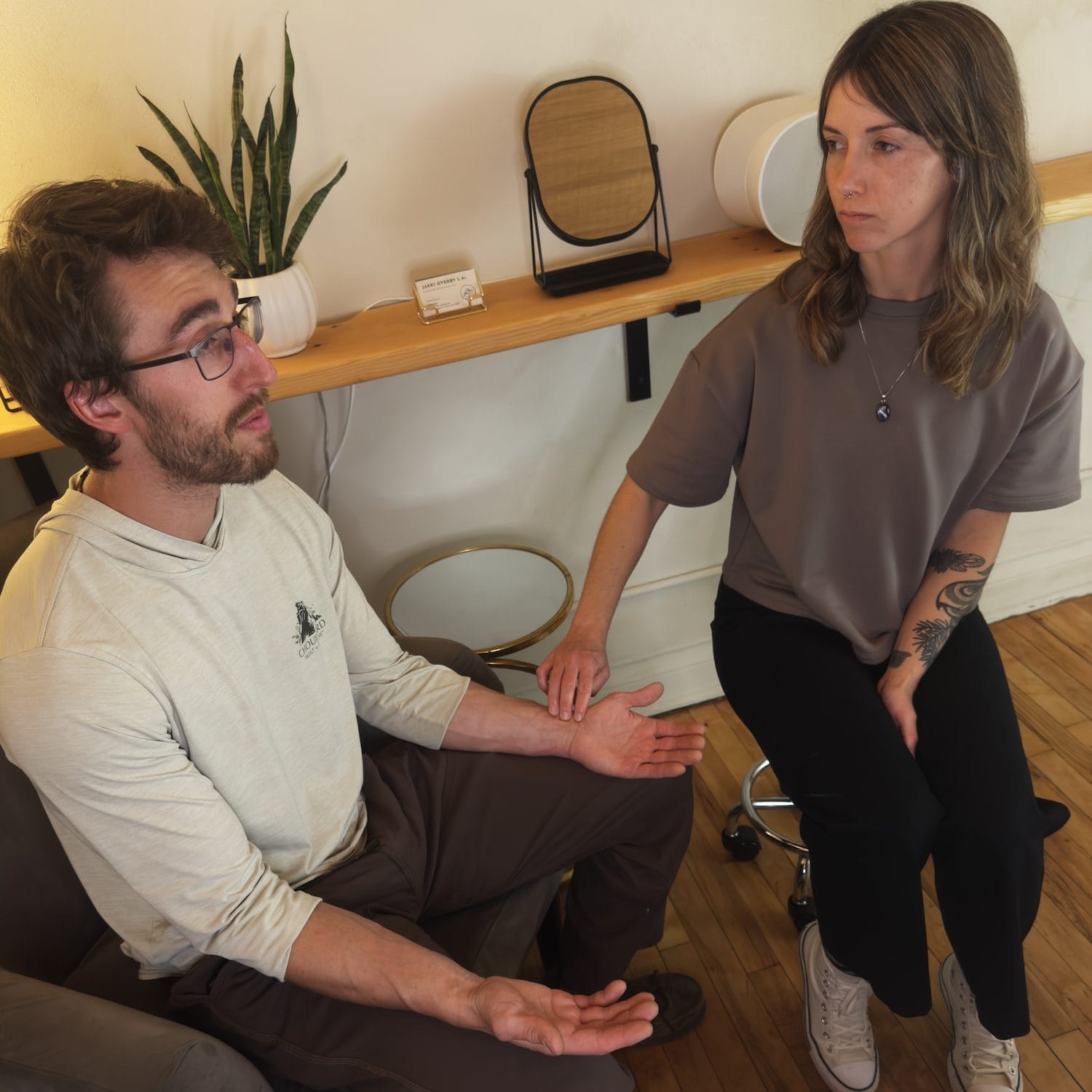 Acupuncturist Jakki Overby assesses a client's pulse in their left forearm according to TCM practices.