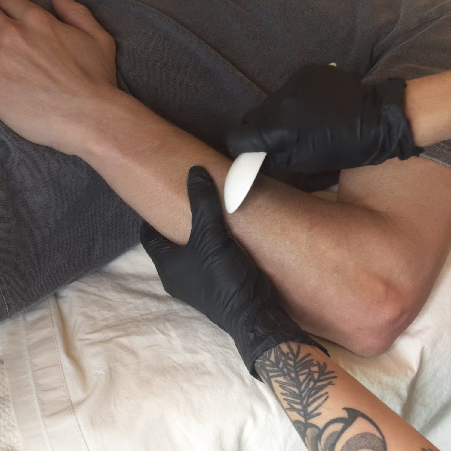 Acupuncturist Jakki Overby uses a Gua sha spoon to scrape along the muscles of a client's forearm.