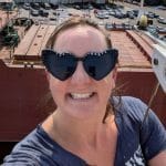 Thai massage therapist Mary Claire (MC) Picard smiling with a ship in the background